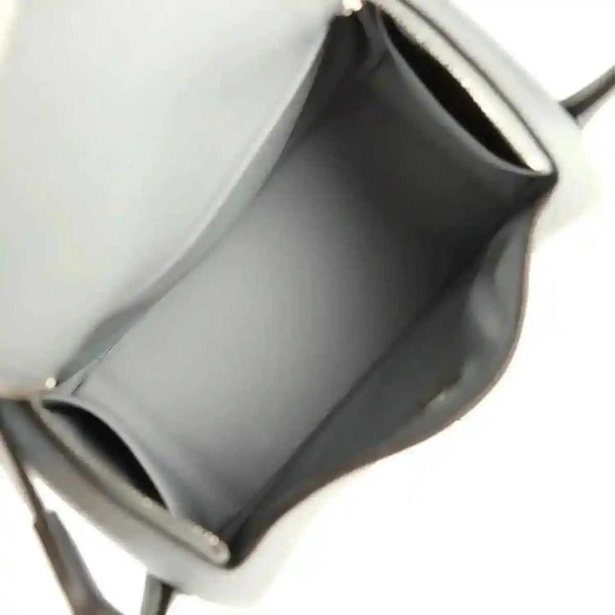 Mini leather handbag interior with smooth lining and stitched edges, gray tone