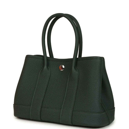 Green leather tote handbag with top handles and structured front panel design