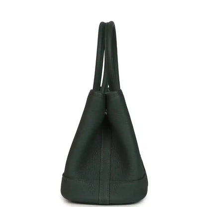 Dark green leather handbag with curved top handles, structured body, and bottom panel
