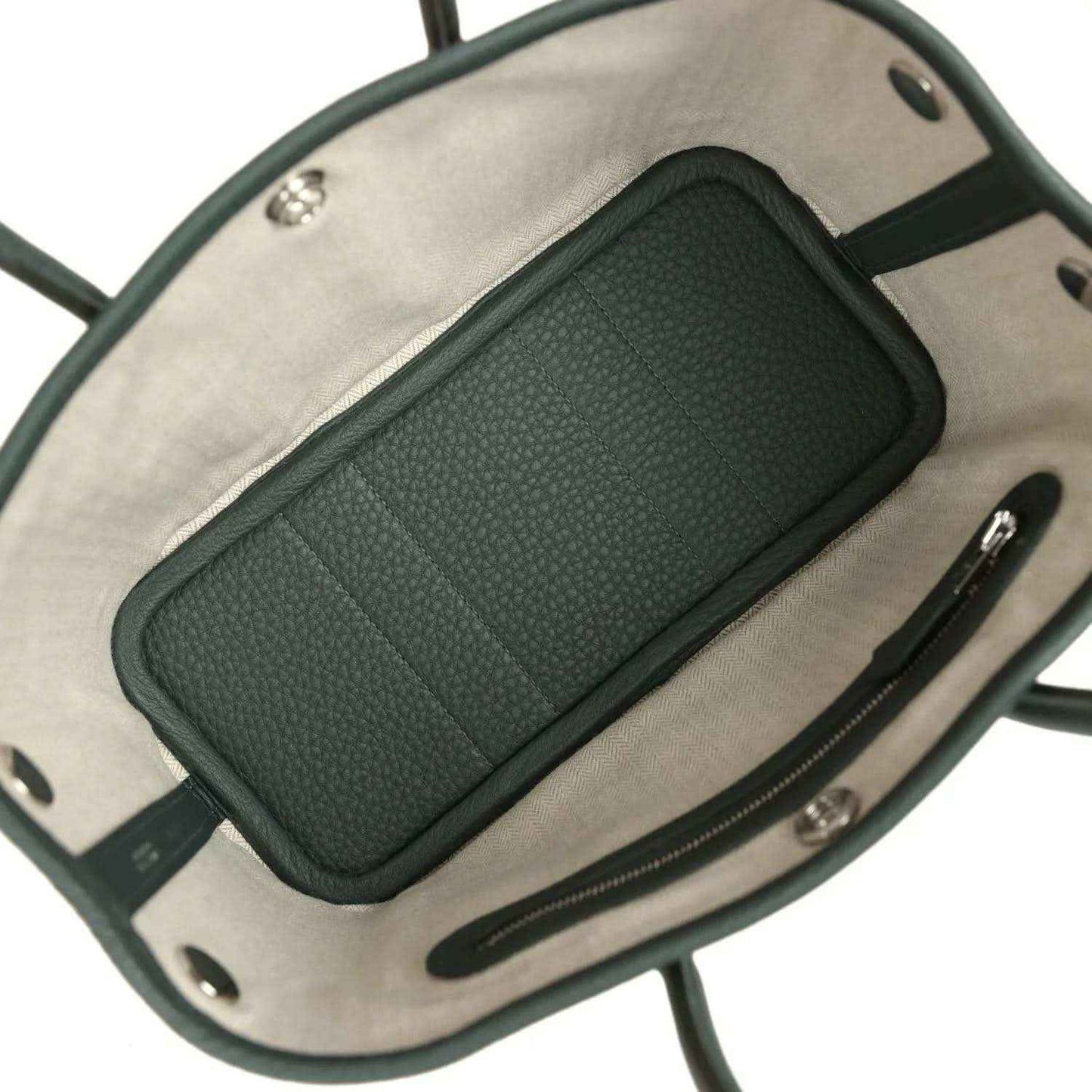 Green leather pocket insert inside a tote, set against light fabric lining