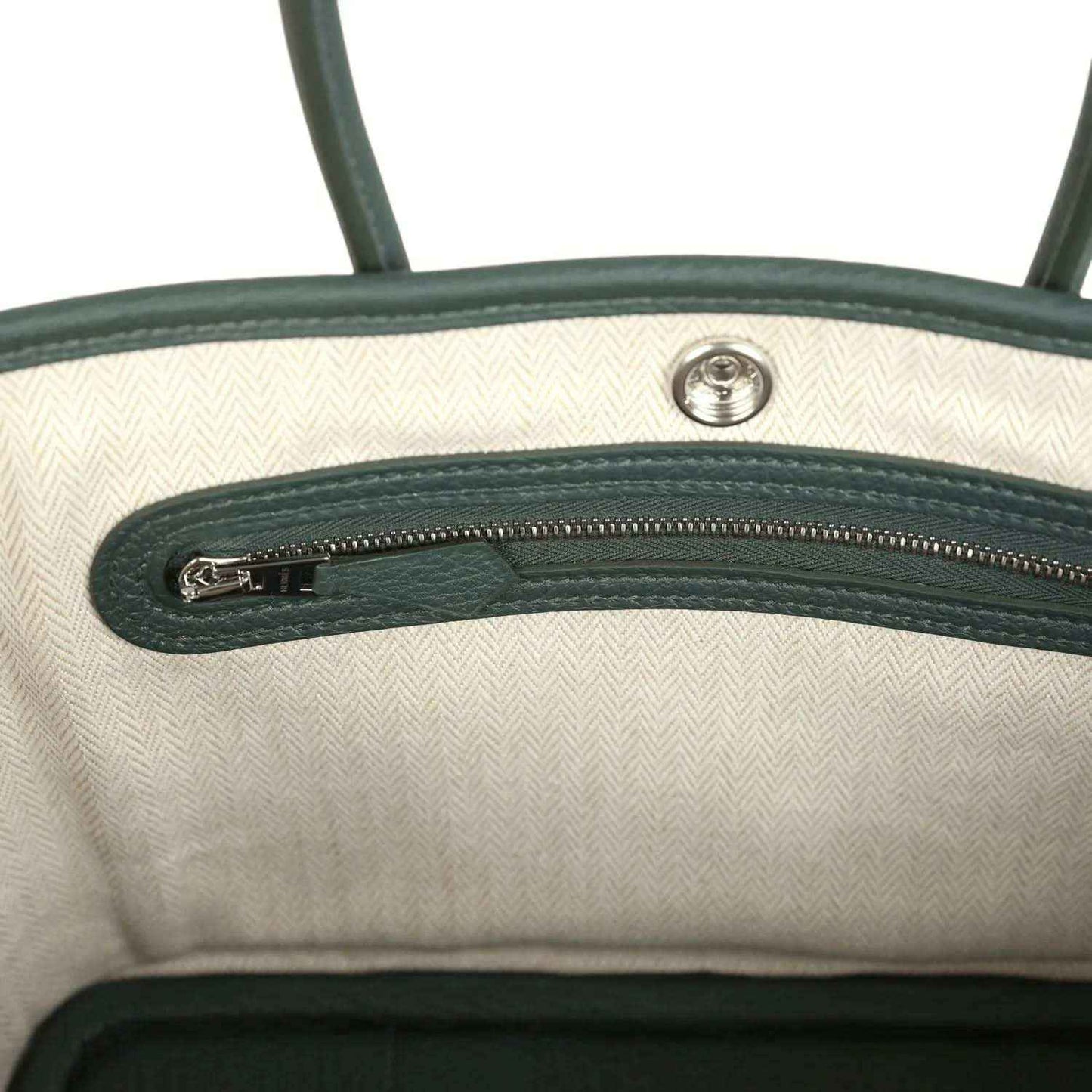 Open tote interior with light lining and green leather top zipper detail
