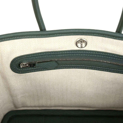 Open tote interior with light lining and green leather top zipper detail