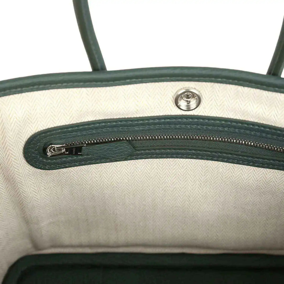 Open tote interior with light lining and green leather top zipper detail