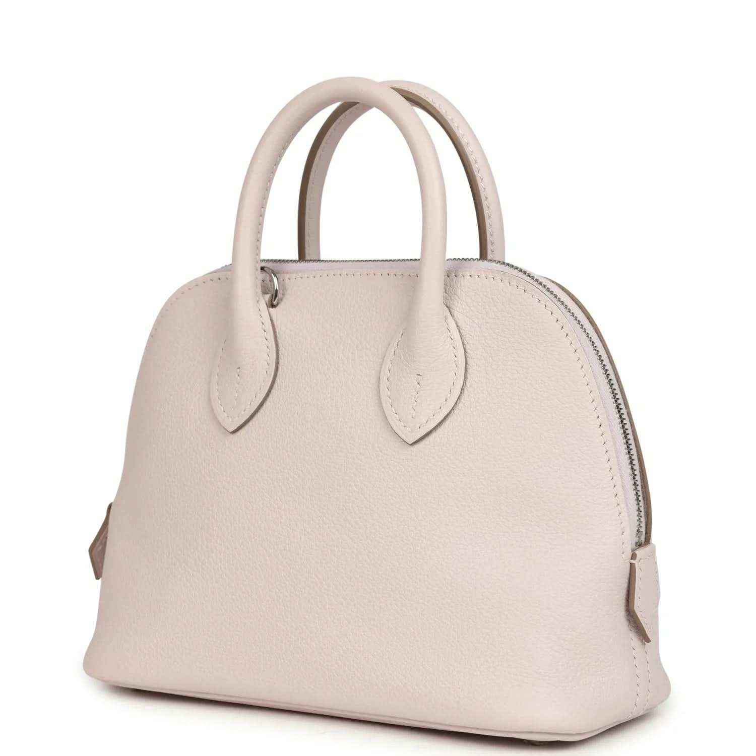 Mauve mini handbag with front yoke, zipper top, and two leather handles