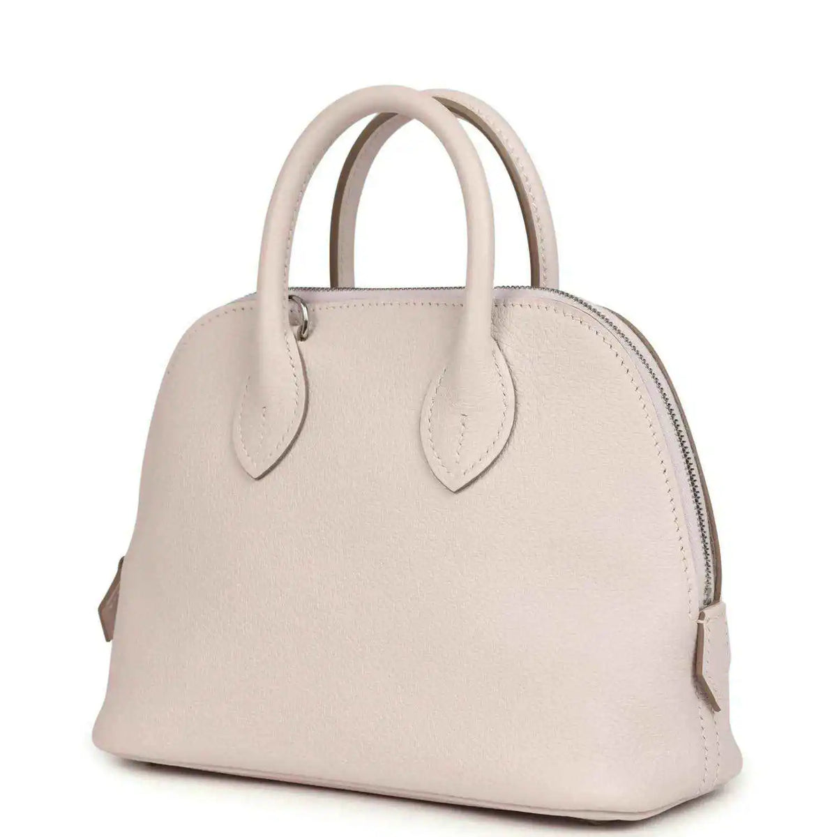 Mauve mini handbag with front yoke, zipper top, and two leather handles