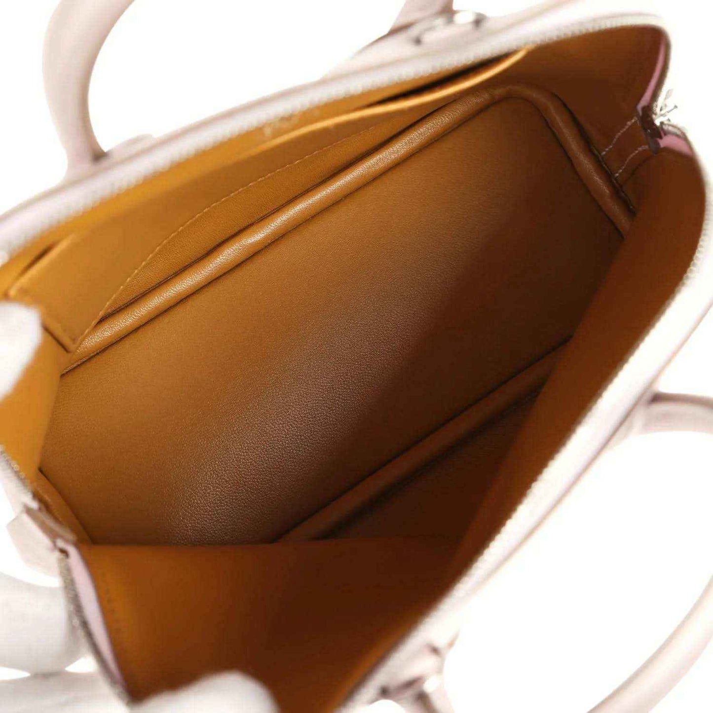 Mini handbag interior with tan leather lining and open zip-top