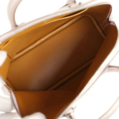 Mini handbag interior with tan leather lining and open zip-top