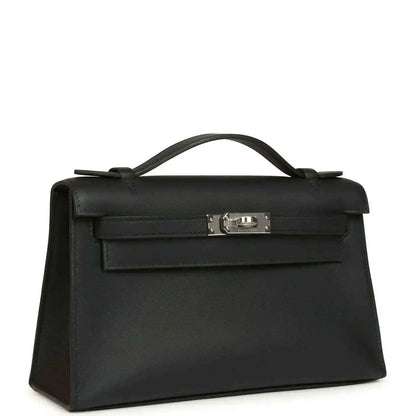 Hermes Kelly pochette handbag angled view in black leather with palladium clasp