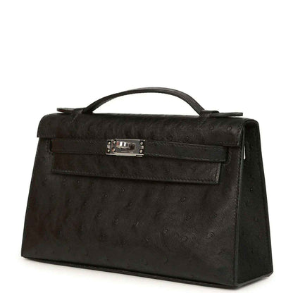 Black ostrich leather clutch with top handle, front flap and silver-tone clasp, side view