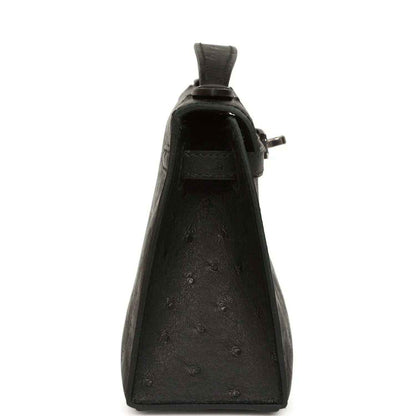 Black ostrich leather clutch, back view with side loop handle and hardware
