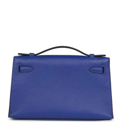 Electric blue leather pochette with top handle, flap closure, and stitched details