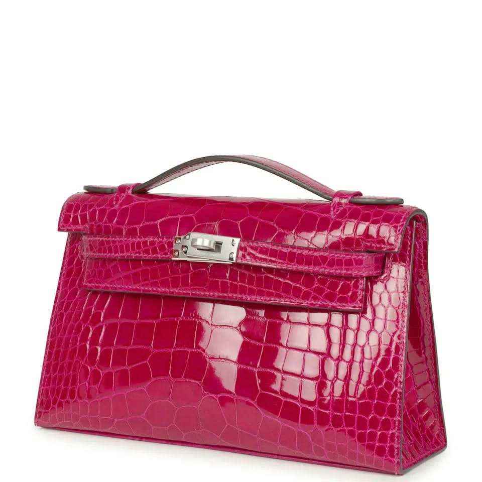 Magenta crocodile-effect Kelly-style handbag with top handle, metal clasp closure
