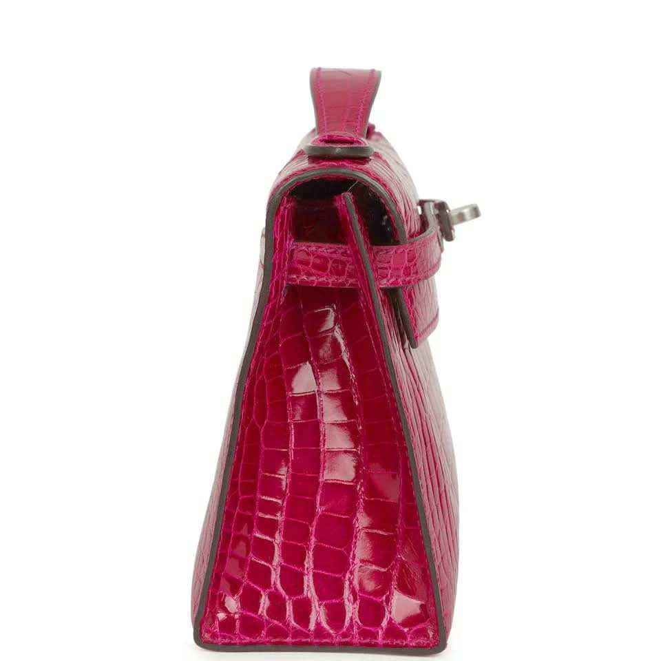 Magenta crocodile-effect leather mini handbag with top handle and side flap