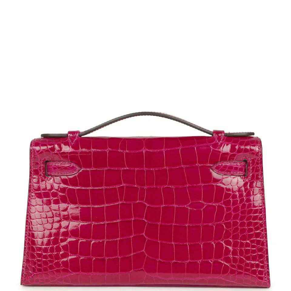 Magenta crocodile-effect handbag with front flap and brushed metal turn-lock