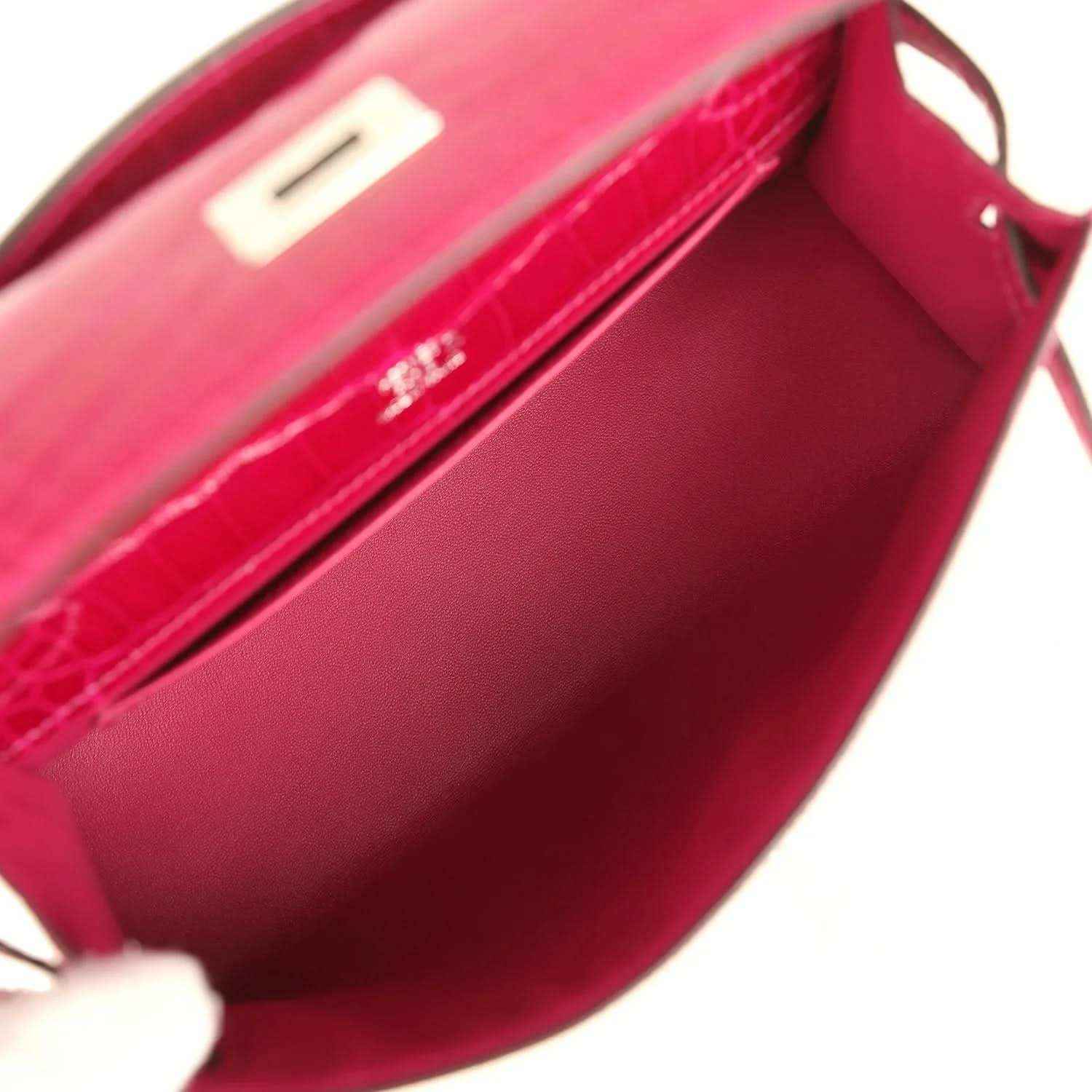 Interior view of magenta crocodile-effect leather mini handbag with flap pocket