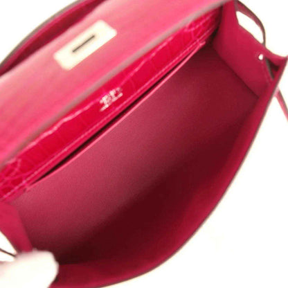 Interior view of magenta crocodile-effect leather mini handbag with flap pocket