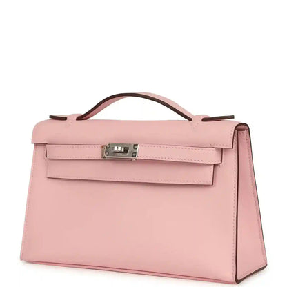Hermes Kelly pochette bag in rose pink leather with front flap, handle, and side panel