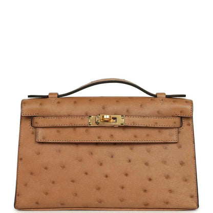 Tan textured leather clutch with gold front turn-lock and structured flap