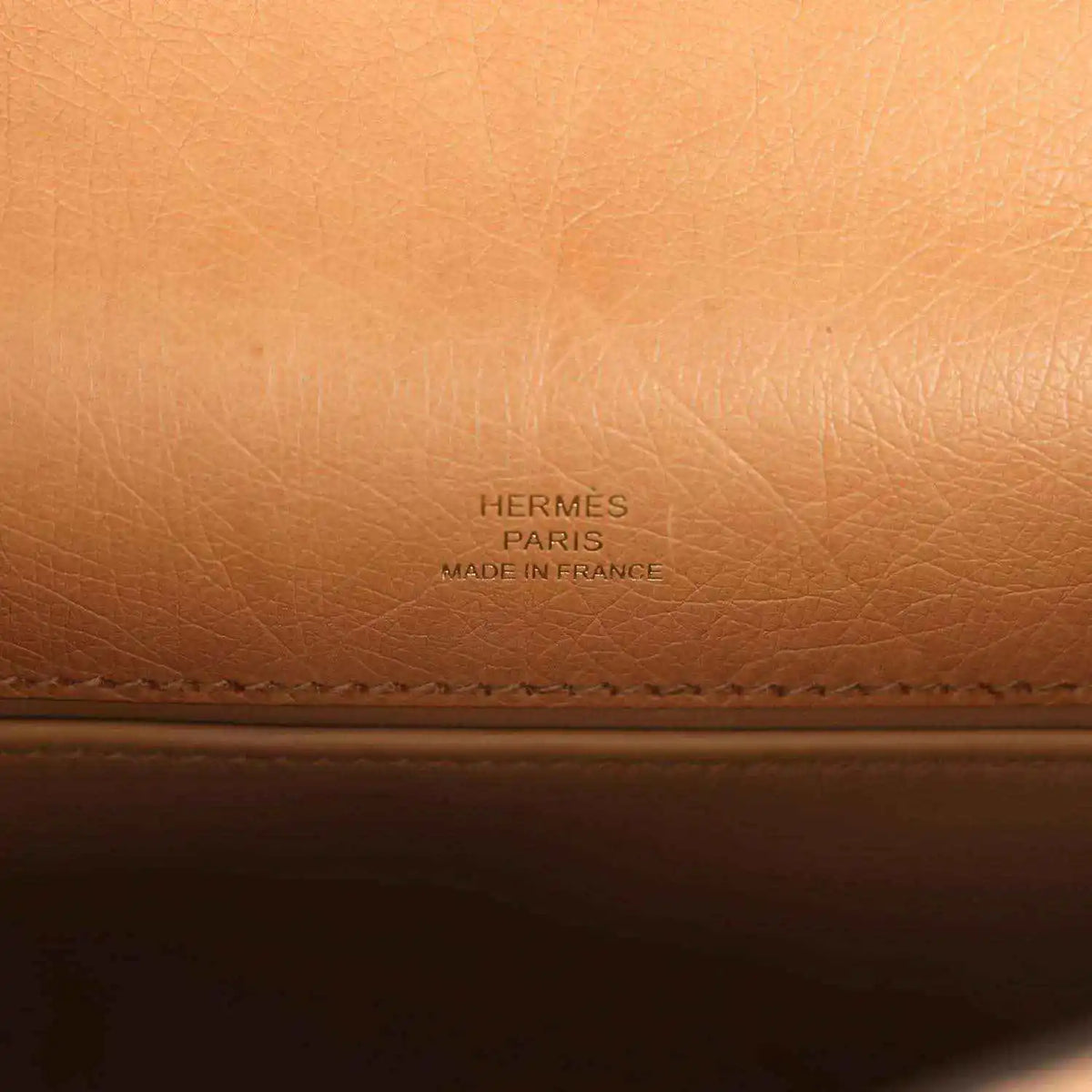 Embossed “HERMES PARIS” brand text on tan leather lining