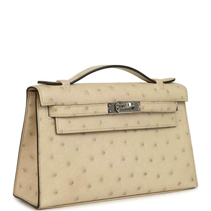 Beige ostrich-leather clutch with curved handle and front flap, side profile