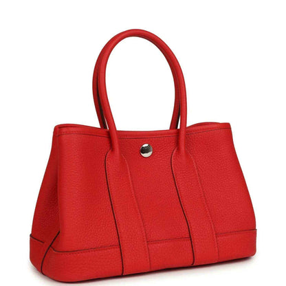 Red togo leather tote bag with top handles, structured front panels, and metal snap