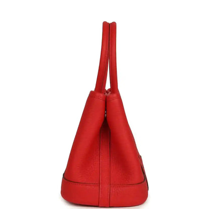 Red leather tote bag with two top handles and bucket-style top opening