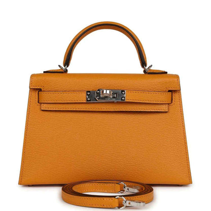 Mustard yellow leather top-handle handbag with front flap and metal turn-lock clasp