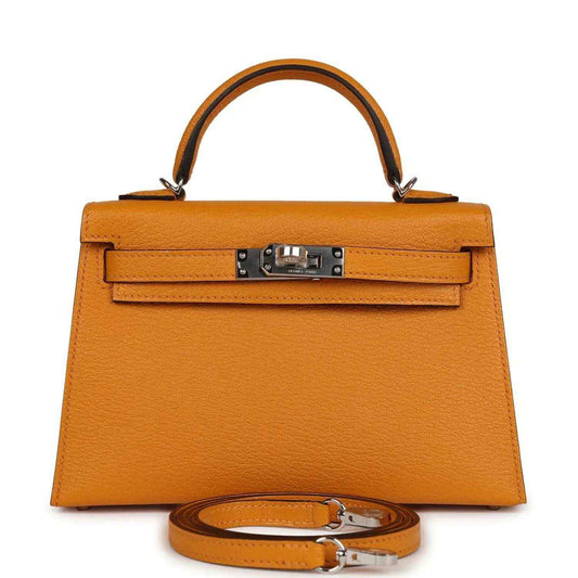 Mustard yellow leather top-handle handbag with front flap and metal turn-lock clasp