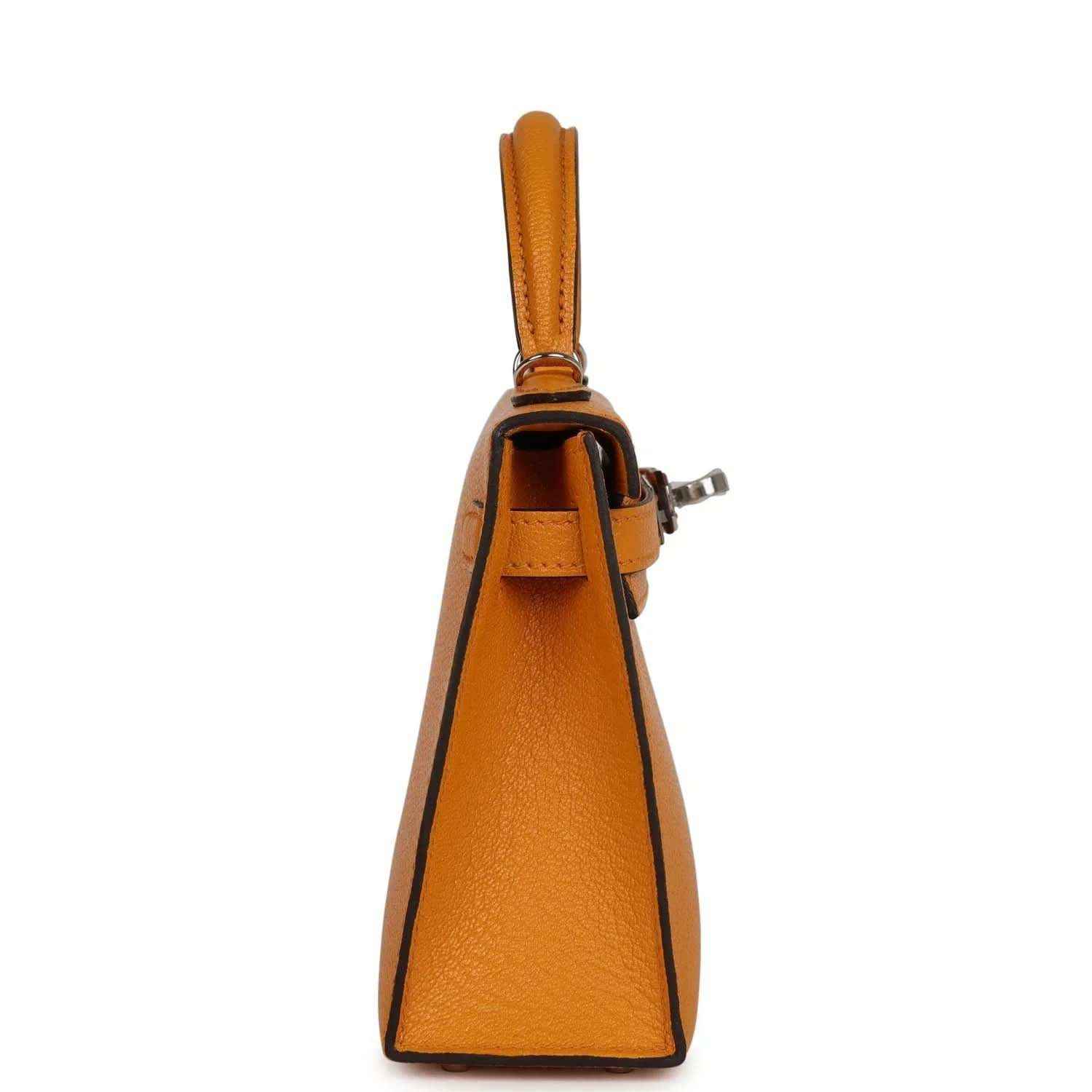Mustard yellow leather top-handle handbag with side stitching and adjustable shoulder strap