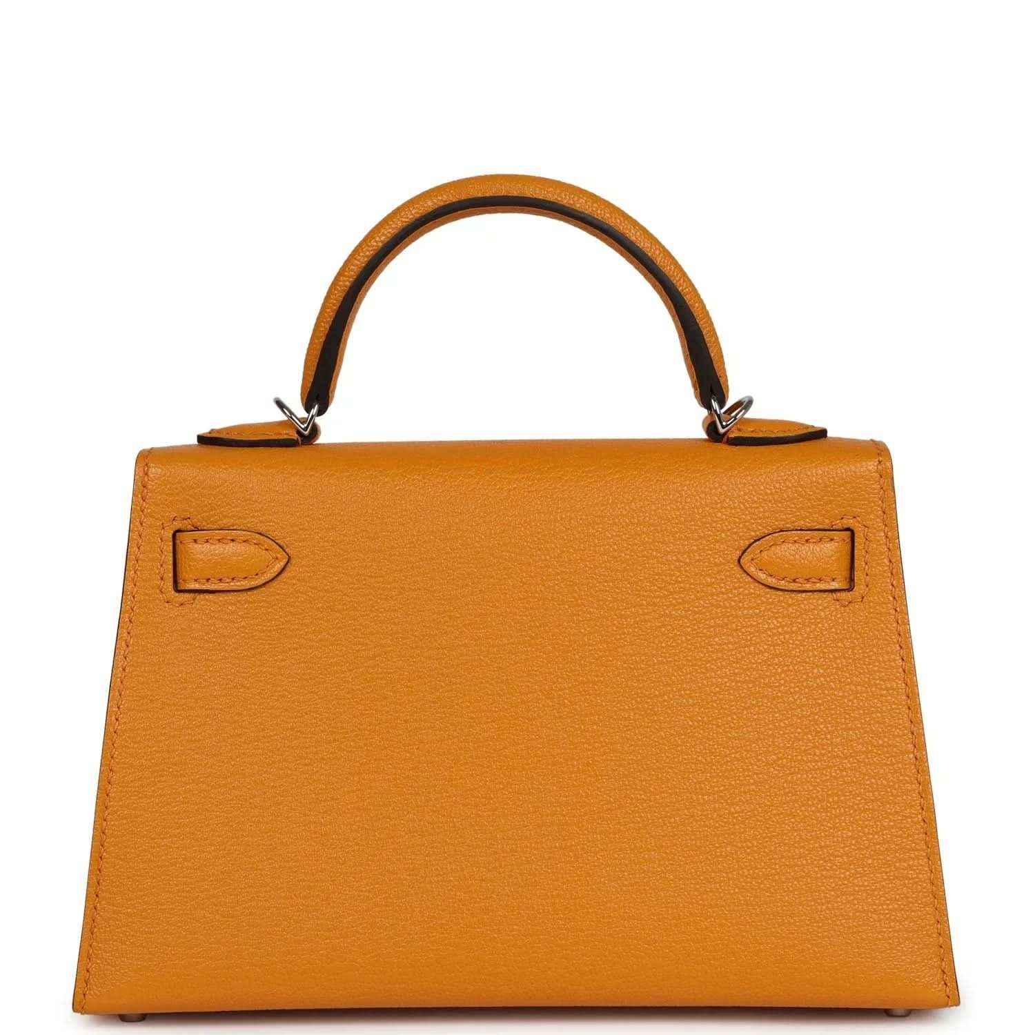 Mustard yellow leather handbag with front flap, corner cutouts, and top handle