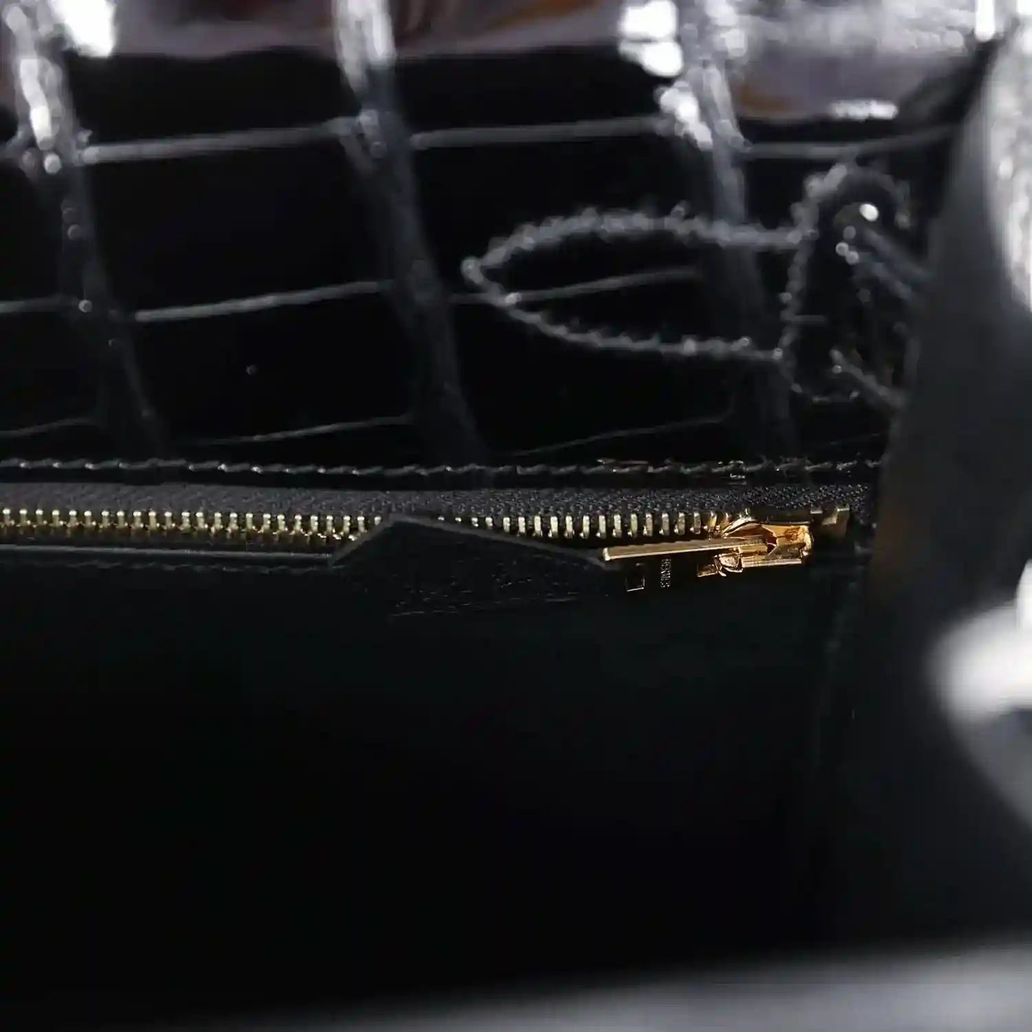 Gold zipper track and pull on black alligator leather handbag interior