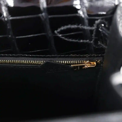 Gold zipper track and pull on black alligator leather handbag interior