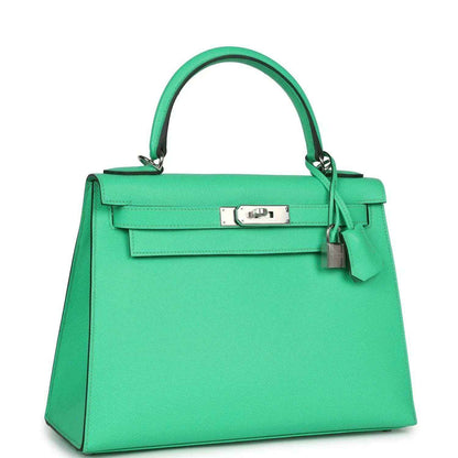 Green leather top-handle handbag with front flap clasp and side panel stitching