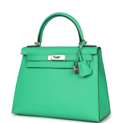 Green leather top-handle handbag with silver nameplate, front clasp, and charm
