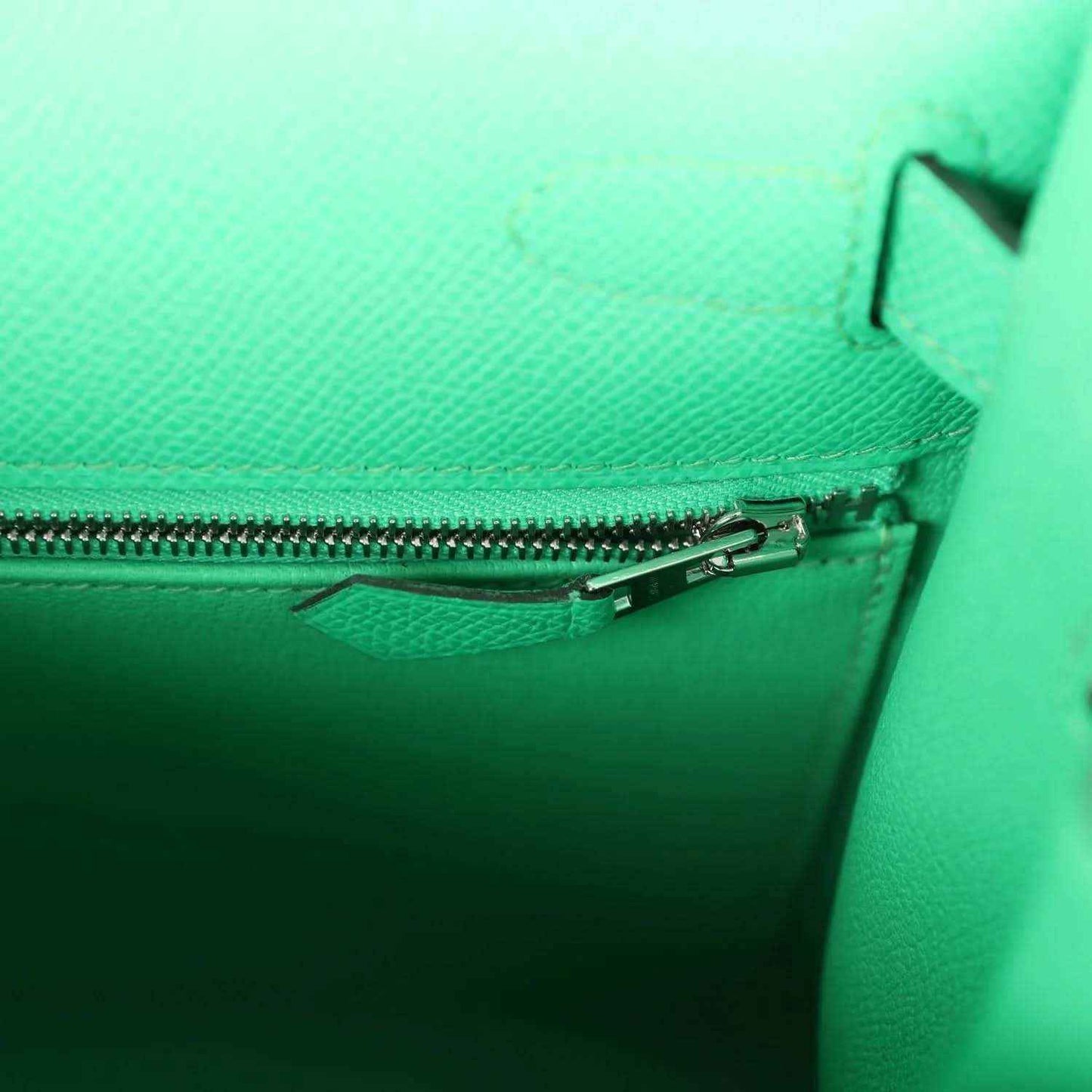 Green leather handbag pocket with zipper track and small pull tab