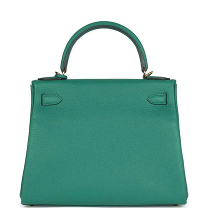 Green leather handbag with top handle, embossed back panels, and gold-tone feet