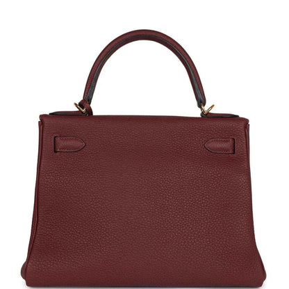 Red leather Hermès Kelly Retourne handbag back view with strap closures