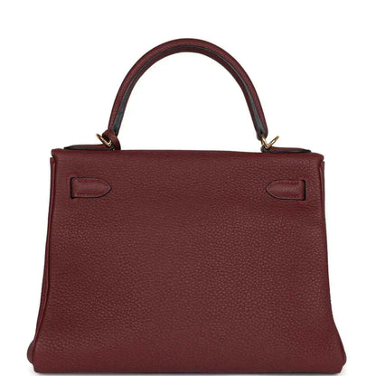 Red leather Hermès Kelly Retourne handbag back view with strap closures