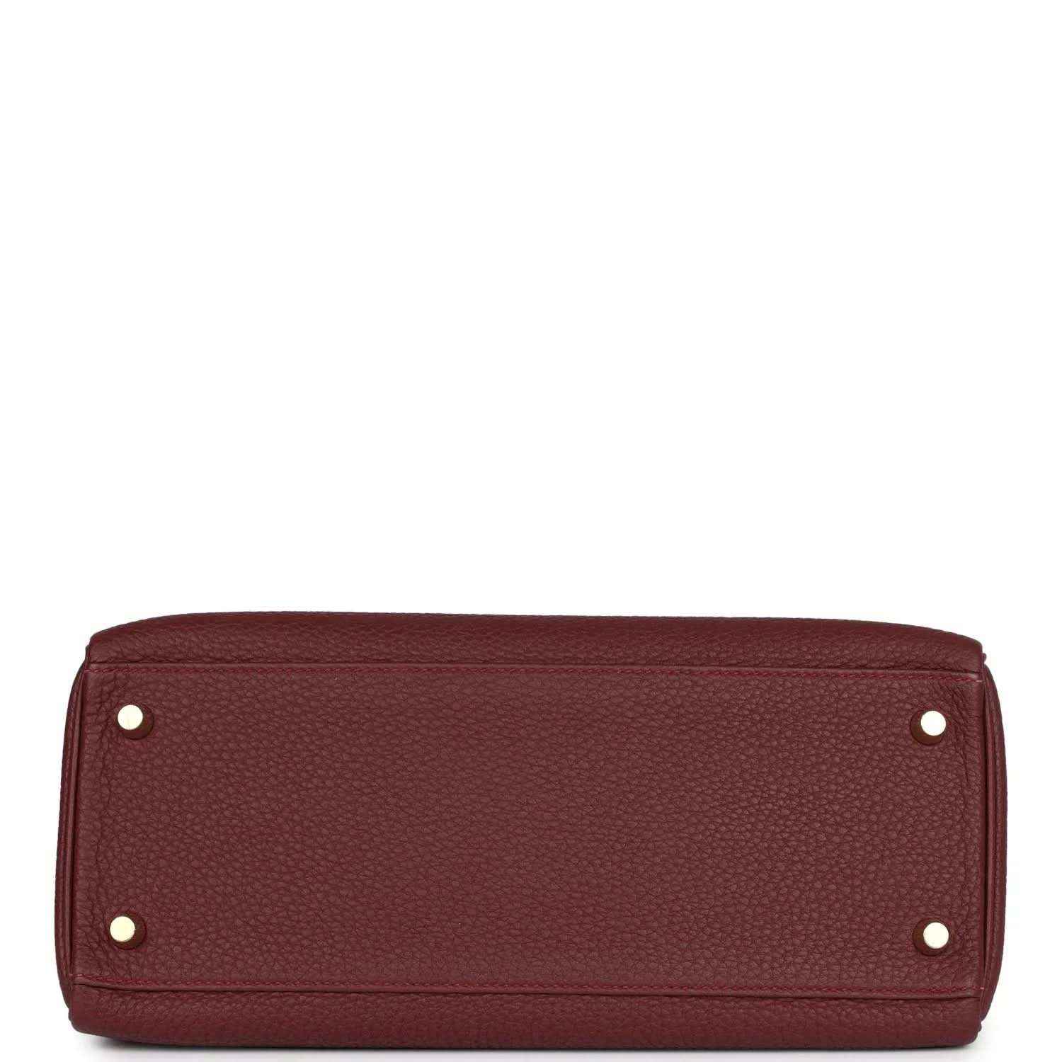 Red leather Hermès Kelly Retourne handbag base with metal feet and rivets