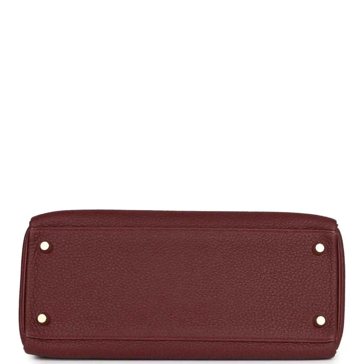 Red leather Hermès Kelly Retourne handbag base with metal feet and rivets