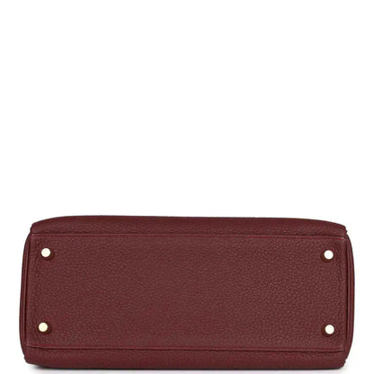 Red leather Hermès Kelly Retourne handbag base with metal feet and rivets