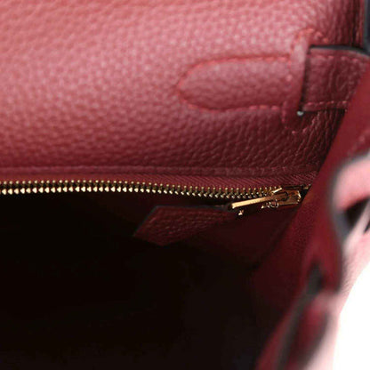 Red leather Hermès Kelly Retourne handbag with gold zipper and interior pocket