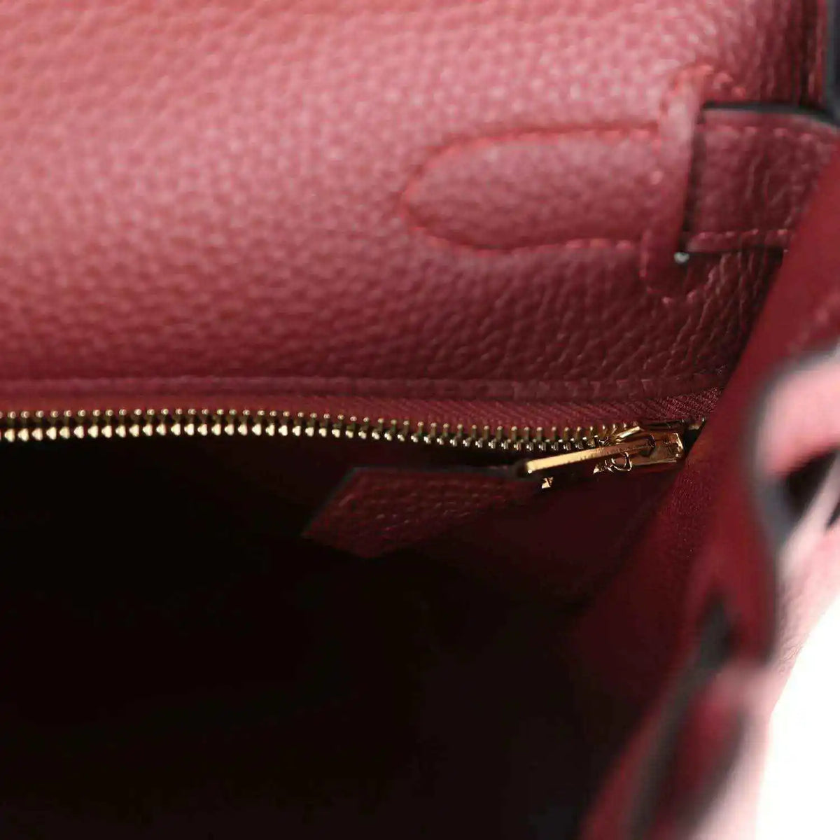 Red leather Hermès Kelly Retourne handbag with gold zipper and interior pocket