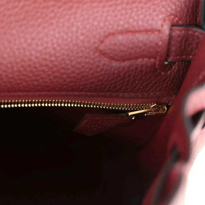 Red leather Hermès Kelly Retourne handbag with gold zipper and interior pocket