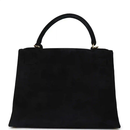 Black suede top-handle handbag with structured front and gold handle hardware