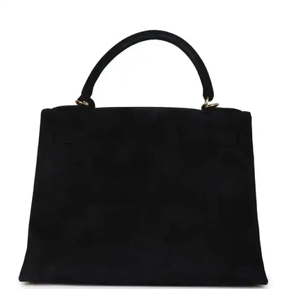 Black suede top-handle handbag with structured front and gold handle hardware