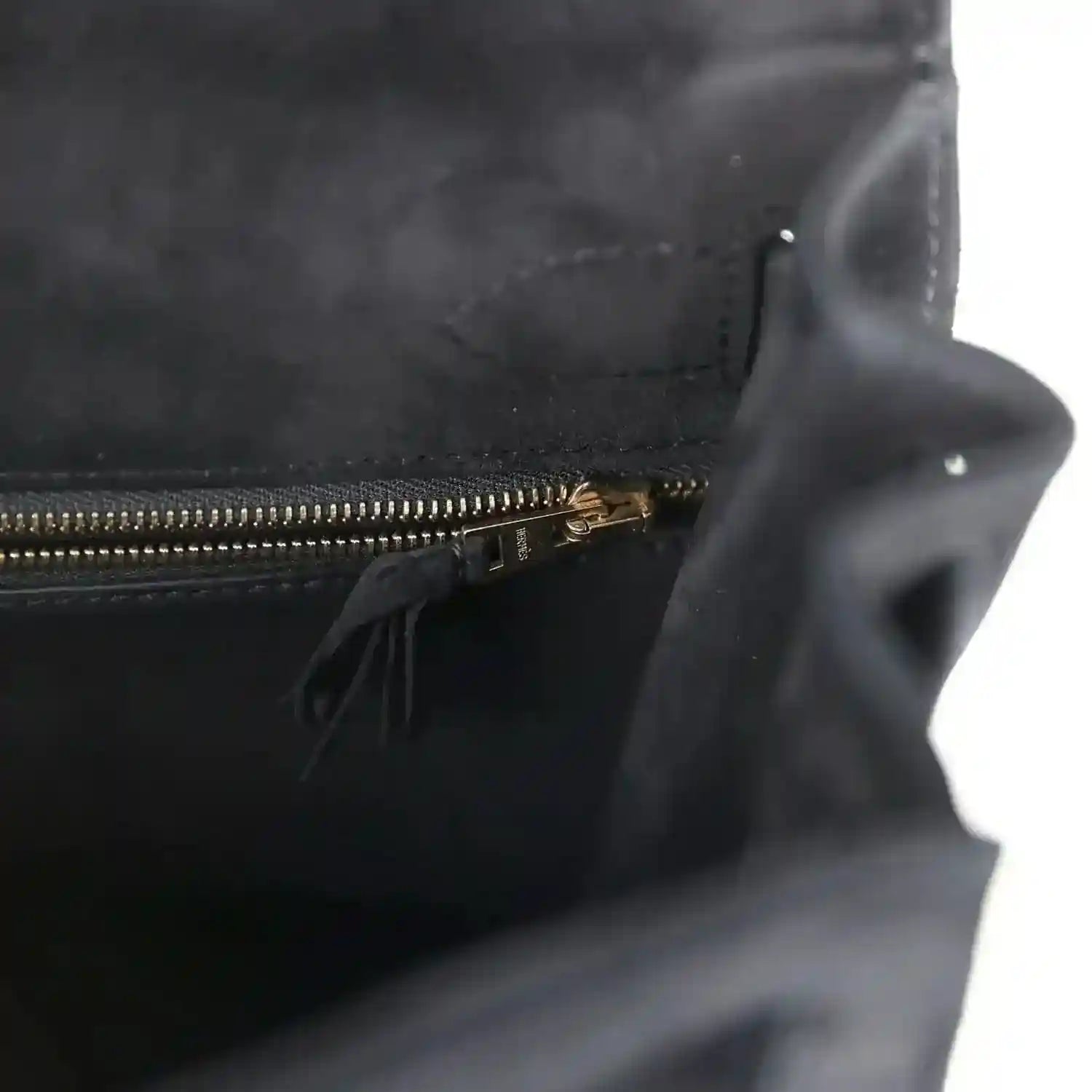 Black suede interior with gold zipper and small tassel pull