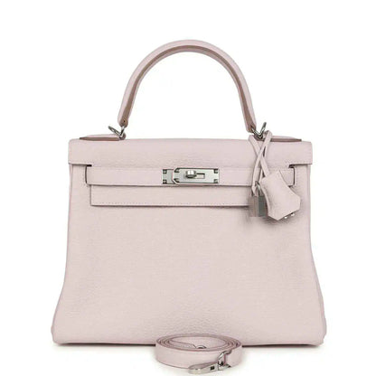 Light mauve leather handbag with top handle, front flap, and silver-tone clasp hardware