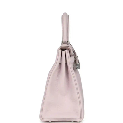 Light mauve leather handbag side view with top handle and stitched base corners