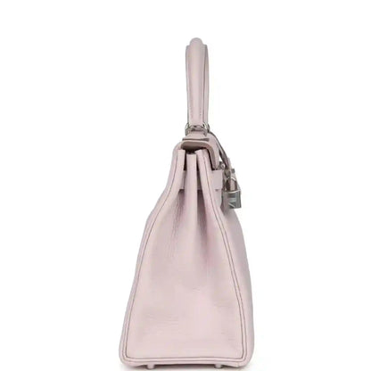 Light mauve leather handbag side view with top handle and stitched base corners